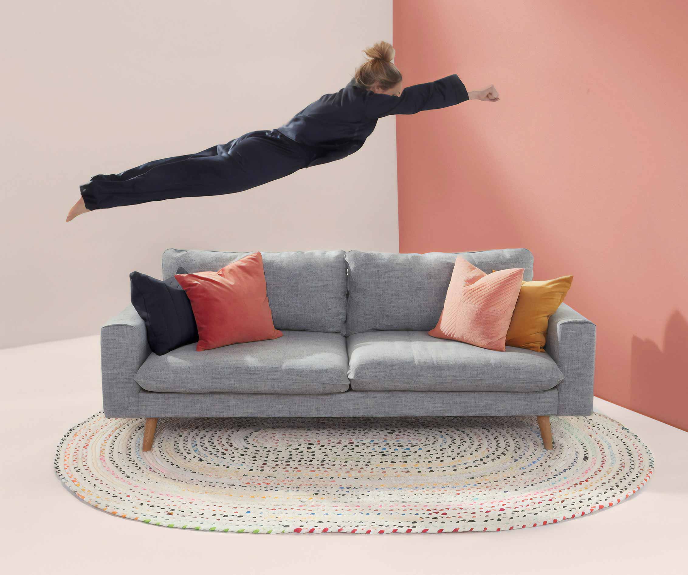 Person Jumping onto Gray Couch